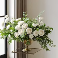 Golden Vase With White Roses And Green Leaves Floral Arrangement On Table