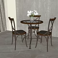 Round Wooden Dining Table With Cross Back Chairs And White Flower Vase In Modern Interior