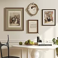 Framed Artworks On Wall With White Round Table Green Apples Books And Black Chair