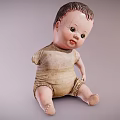 Vintage Baby Doll With Worn Cloth Outfit Sitting In Classic Pose