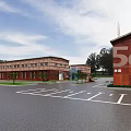 Red Brick Industrial Factory Building With 5G Signage Parking Lot Green Trees And Clear Sky