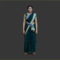 Woman In Green Saree With Blue Yellow Accents And Bangles Against Grey Background