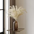 Brown Glass Vase With White Feathery Flowers On Glass Table By Window Curtain