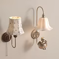Two Decorative Wall Lamps With Floral And White Lampshades Brown Silver Bases And Angel Decoration