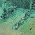 Steam Locomotive In Railway Yard With Old Warehouse And Equipment