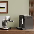Silver And Black Espresso Coffee Machines On Wooden Countertop With Green Wall