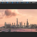 Industrial Oilfield Architecture With Tall Towers Pipes And Flaming Torch Under Sunset Sky