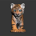 Tiger Cub Toy With Orange Black Stripes And Blue Eyes Standing On Reflective Surface