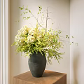 Gray Ceramic Vase With White Hydrangeas And Green Foliage In Minimalist Room On Wooden Table