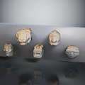Ancient Stone Animal Head Sculptures Display On Transparent Panel With Square Carving