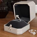 Elegant Diamond Ring Inside Open Jewelry Box With Pearl Detail And Small Ring On Wooden Table