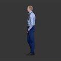 Man In Blue Shirt And Blue Pants Standing With Hands In Pockets Against Gray Background