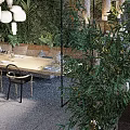 Open Restaurant Interior With Lush Greenery Natural Light Cozy Seating And Wooden Dining Tables