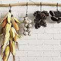 Hanging Various Types of Crops on Wooden Pole Against White Brick Wall