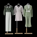 Mannequins Displaying Green Blouse White Wide Leg Pants Polka Dot Dress And Green Suit Set
