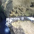 Natural Water Fountain In Rocky Terrain With Rushing Water And Green Moss