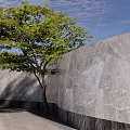 Elegant Garden Landscape with Metal Gate Stone Monument Lush Trees Green Lawn and Circular Design