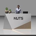 White Exhibition Reception Desk with NUTS Logo Potted Plants and Female Staff