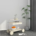 Rolling Side Table With Two Tier Shelves Oranges Book And Vase Near Tall Green Plant