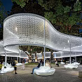 Modern Curved Pergola Design With Evening Lighting Surrounding Trees And Public Rest Area