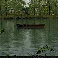 Serene Lake Landscape With Small Boat Sunset Reflection Surrounded By Trees