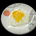 Tasty Fried Egg With Runny Yolk On White Plate With Red Floral Pattern