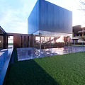 Modern Commercial Complex With Glass Curtain Walls Lawn Trees And Evening Lighting Open Public Space