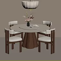 Round Wooden Dining Table With Four Chairs Light Colored Cushions Vase Flowers And Hanging Lamp