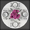 Elegant Dinnerware Set on Round Table with Purple Flower Bouquet and Wine Glasses