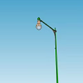 Outdoor Light With Green Pole Curved Arm And Clear Bulb Against Blue Sky