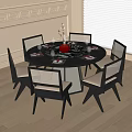 Modern Black Round Dining Table And Chair Set With Mesh Backs And Red Centerpiece