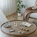 Round Wooden Coffee Table With Clear Glasses Plant Vase Open Book And Teacups
