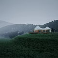 White tent like building on hilltop in misty green meadow with distant mountains