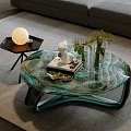 Unique Teal Glass Coffee Table Featuring White Statue Books Vase And Green Plants