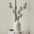 White Marble Vase with Fresh Green Branches Placed Near White Blinds on Table