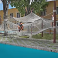 Kindergarten Outdoor Playground Featuring Climbing Net Structure With Children Playing In Green Grass