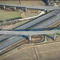 Aerial View Of Interchange Bridge With Multiple Roads Intersecting And Farmland Below
