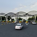 Modern Wave Shaped Toll Booth With Vehicles Passing Through Lanes And Green Surroundings