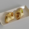 Two Pieces Golden Crust Pastry With Green Filling On White Rectangular Plate