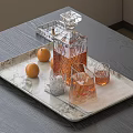 Whiskey Decanter and Glasses on Marble Tray with Oranges on Gray Tabletop and Decorative Elements