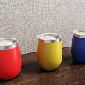 Vibrant Red Yellow Blue Tumblers With Silver Rim Placed On Wooden Table