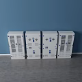 Four White Storage Cabinets With Glass Doors And Blue Accents Against Blue Wall