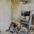 Fire Damaged Kitchen Interior Showing Burned Walls Broken Appliances And Debris
