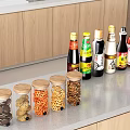 Spice Bottles And Transparent Jars With Snacks On Kitchen Countertop By Wooden Cabinets
