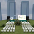 Outdoor Event Stage On Green Lawn With Neatly Arranged White Seats And High Rise Buildings