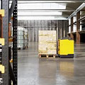 Industrial Warehouse Storage Space With Yellow Metal Shelving Toolboxes Tires And Containers