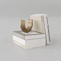 Stacked White And Beige Hardcover Books With Golden U Shaped Decor