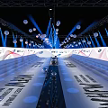 Modern Stage With Blue Lighting Hanging White Spherical Decorations Staircase Seats And Brand Logos Backdrop