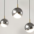 Modern Silver Spherical Pendant Lights With Gold Metal Fittings Glowing Against Light Background