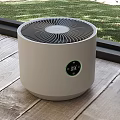 Round White Air Purifier With Digital Display On Wooden Floor Near Window